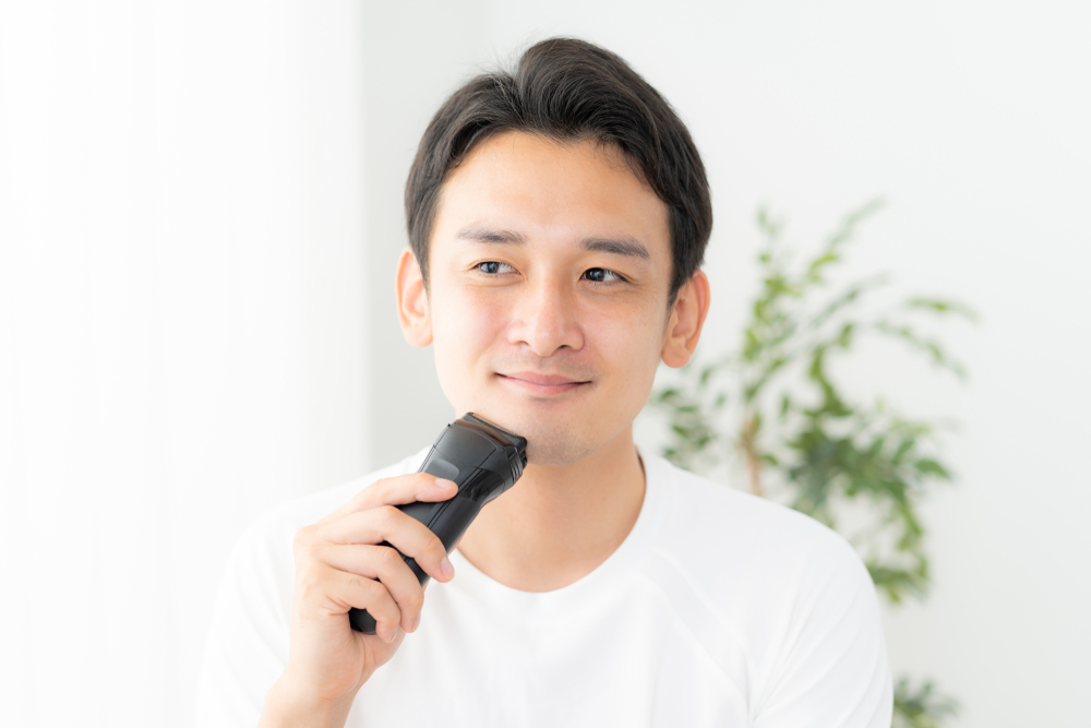 電動シェーバーで髭剃り中