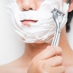 剃刀で顔を剃る男性