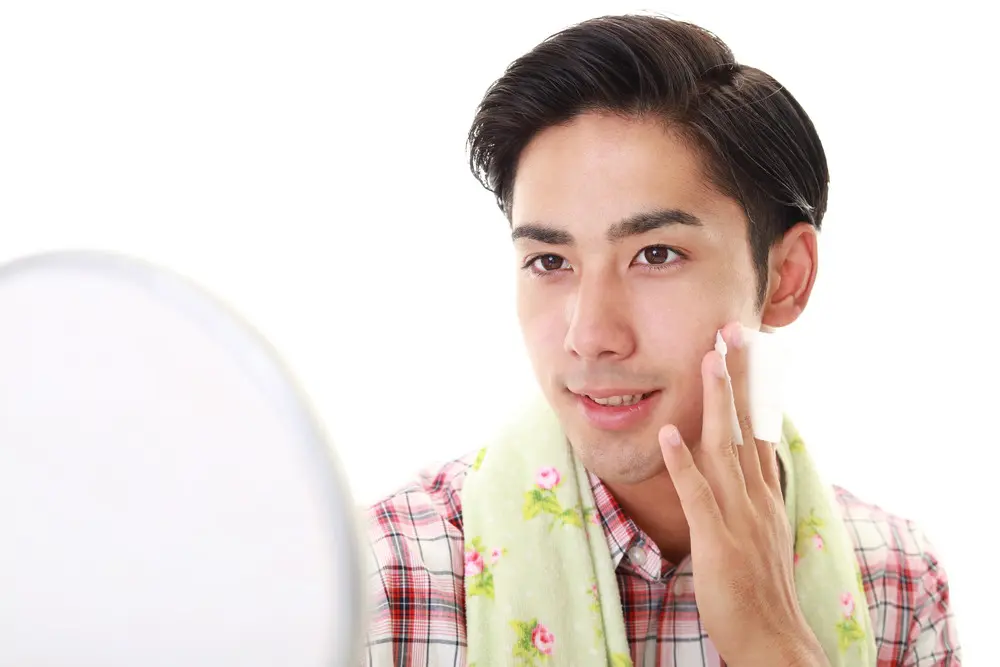 鏡で顔を見る男性