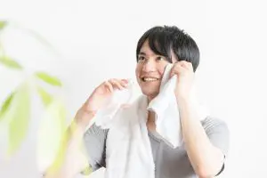 汗をタオルで拭う男性