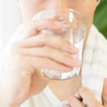 コップで水を飲む