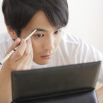 眉をかく男性