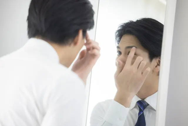 眉毛のチェックをする男性