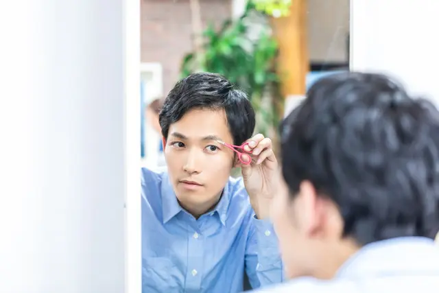 眉の手入れをする男性