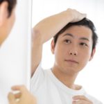 鏡を見る男性