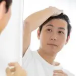 鏡を見る男性