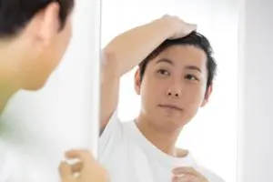 鏡を見る男性