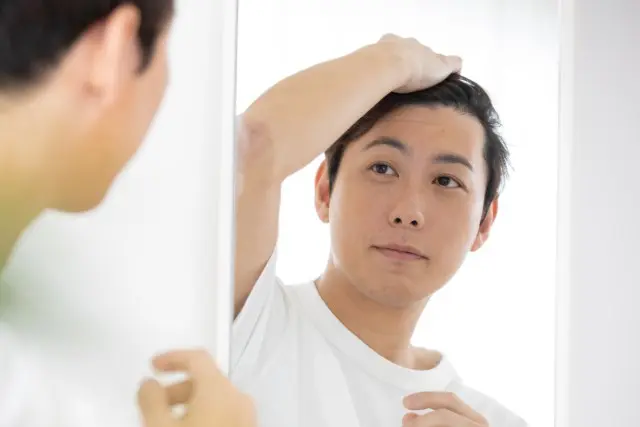 鏡を見る男性