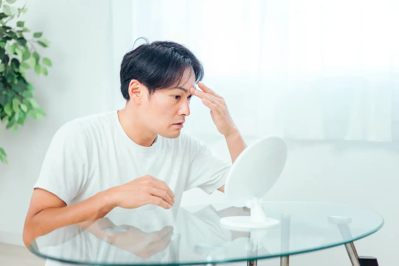 鏡でチェックする男性