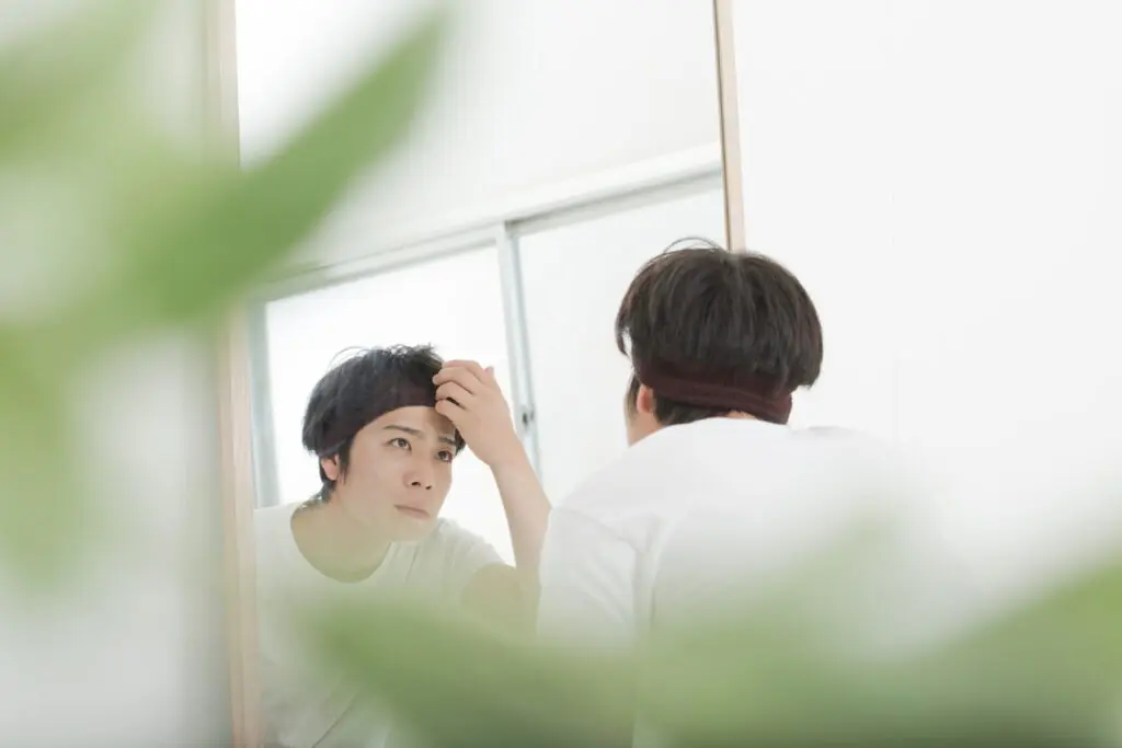 鏡で眉毛をチェックする