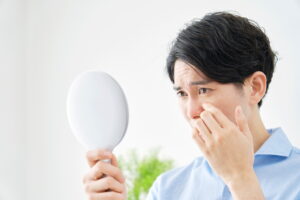 鏡を見て不安になる男性