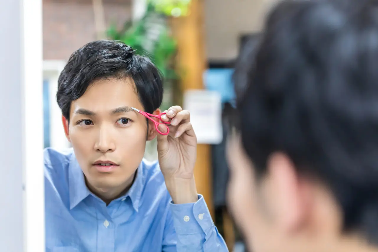 眉毛を整える男性