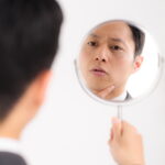 自分の顔を気にする男性