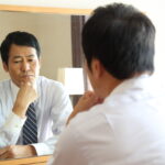 鏡の前で悩む男性