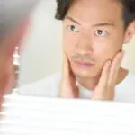 鏡を見る男性