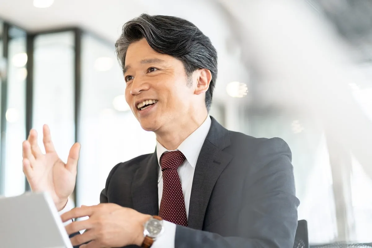 ビジネスシーンで自信を持って話すエグゼクティブ。メンズTransATTが目指す印象